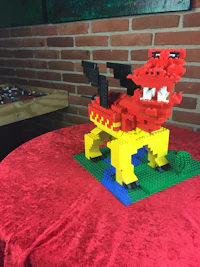 a lego dragon sitting on top of a red table